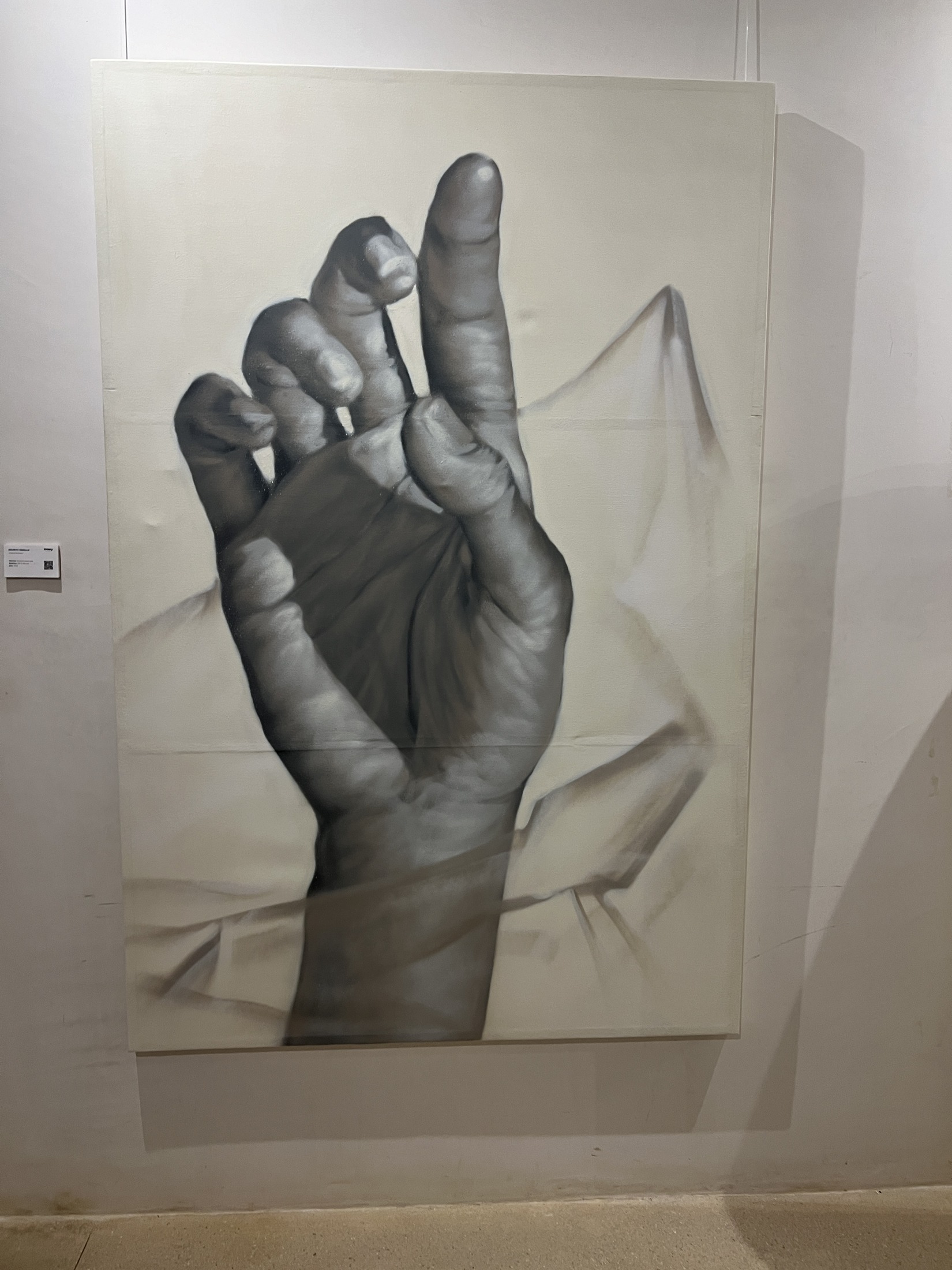 Dibujo grande en blanco y negro de una mano sobre la pared